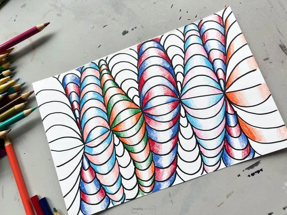 Kolorowe kredki obok rysunku op art łatwe, tworzącego iluzję głębi i ruchu.