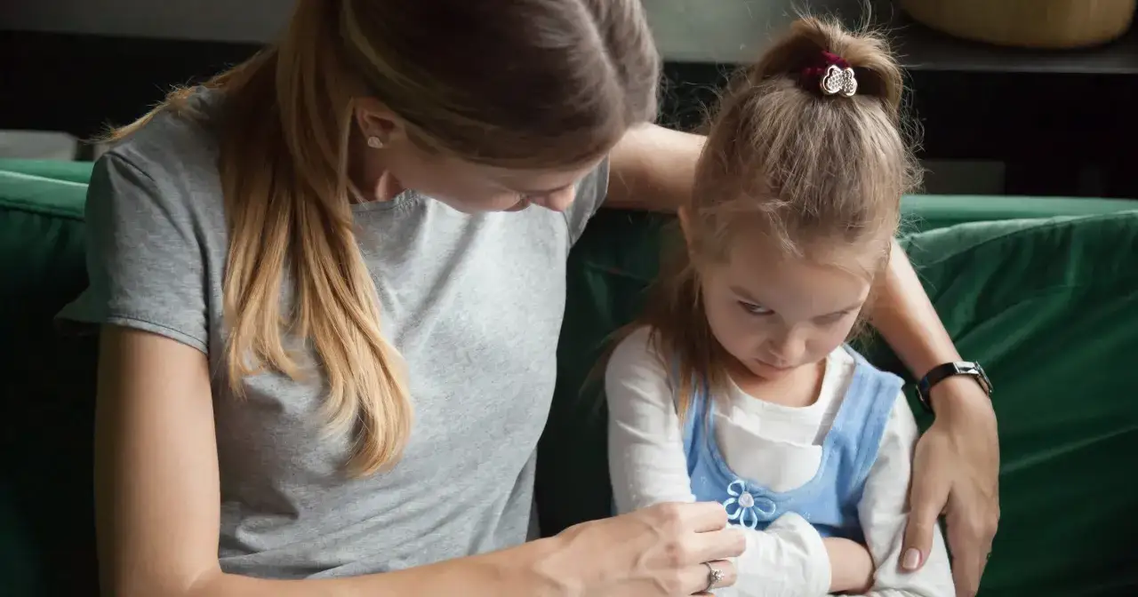 Mama pociesza 3-letnie dziecko, które nie radzi sobie z emocjami.