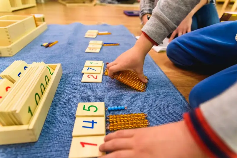 Dzieci uczą się liczyć, używając koralików i kart z cyframi. To świetne zabawy matematyczne klasa 1!